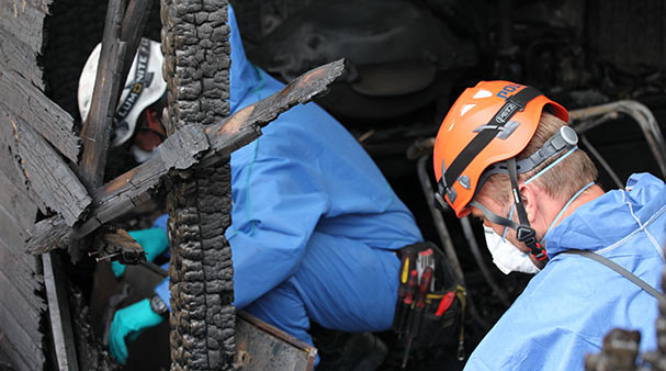 Two fire investigators from DBI examine a fire scene to analyze the fire's development and cause.