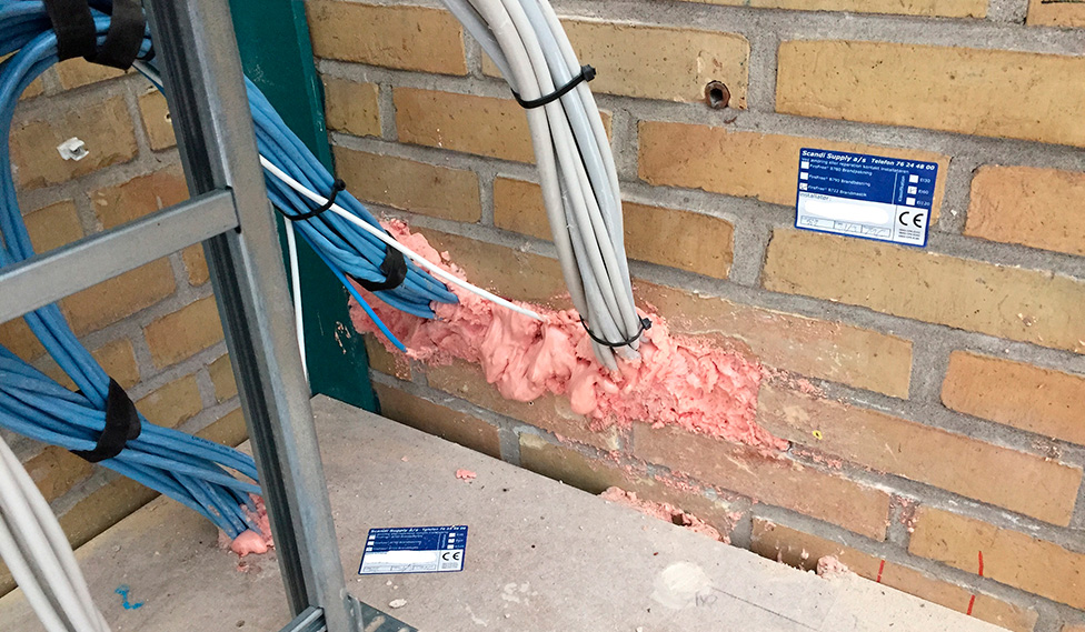 Ukorrekt udførte brandlukninger omkring kabelgennemføringer, der illustrerer brandsektionering, BR18-krav og brandsikkerhed i bygninger.