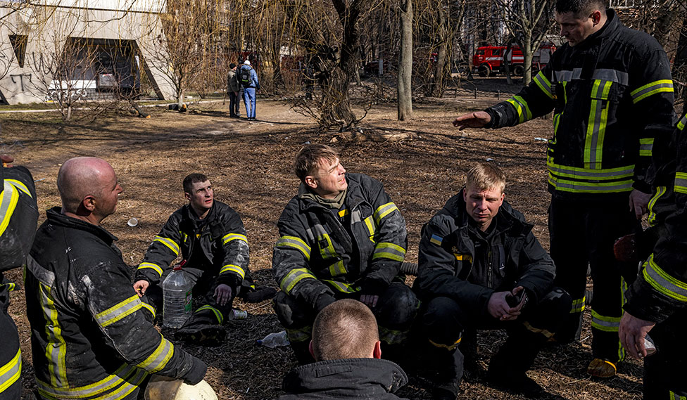 En grupper ukrainske brandmænd sidder og hviler sig.