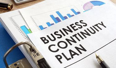 Business continuity plan står skrevet på et stykke papir der ligger over et søjlediagram.