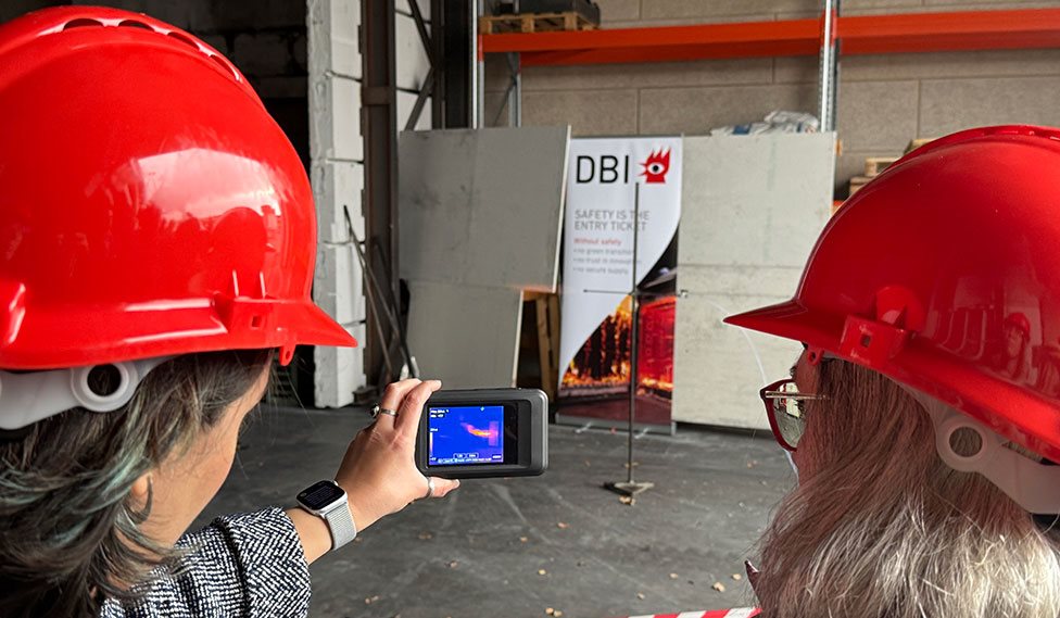 To personer ser på en simulering af den stikflamme der kan komme når der går hul på en brinttank.