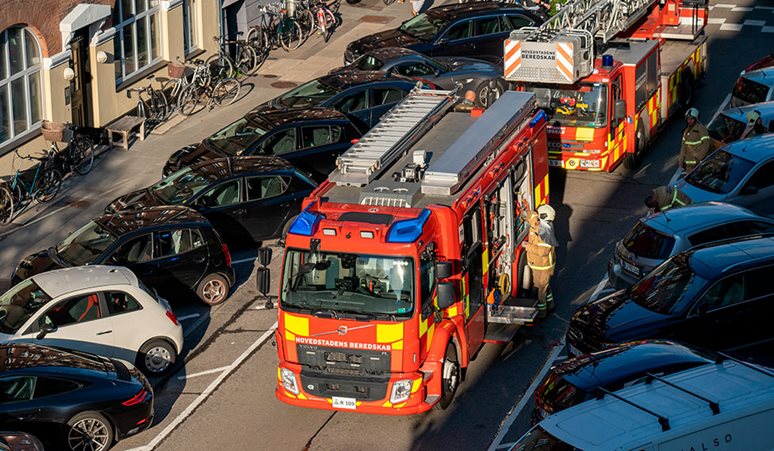 To brandbiler holder imellem to bygninger i København.