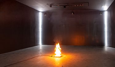 Et mørkt rum, hvor der er lavet et lille bål i midten for til en test.