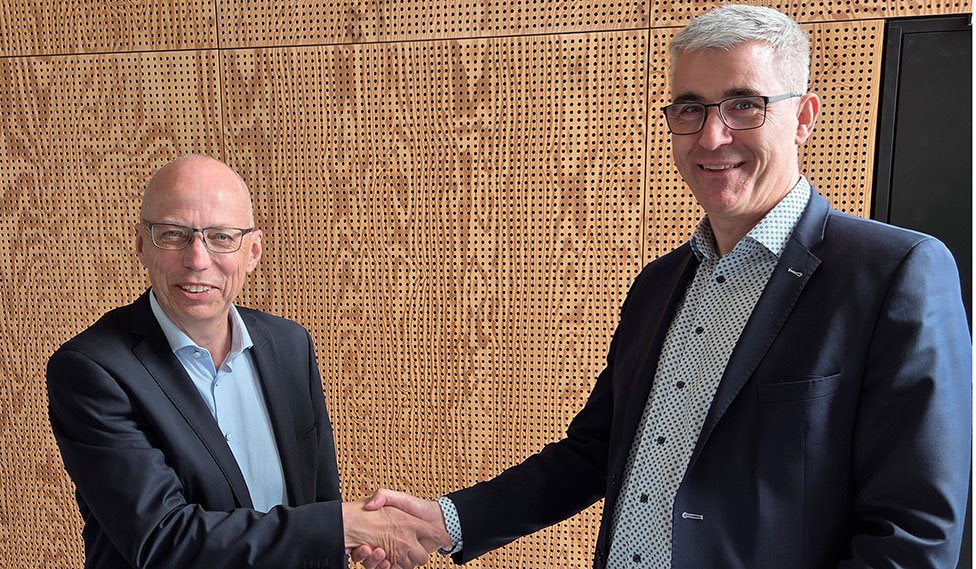 Repræsentanter fra Aalborg Universitet og DBI giver hånd ved underskrivelse af samarbejdsaftale.