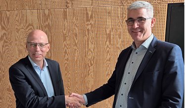 Repræsentanter fra Aalborg Universitet og DBI giver hånd ved underskrivelse af samarbejdsaftale.