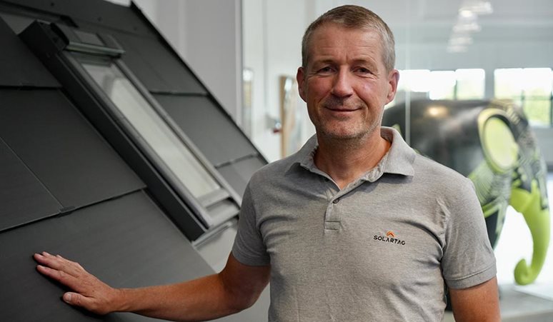 Produkt- og udviklingschef fra Solartag står ved en model af et integreret solcelletag.